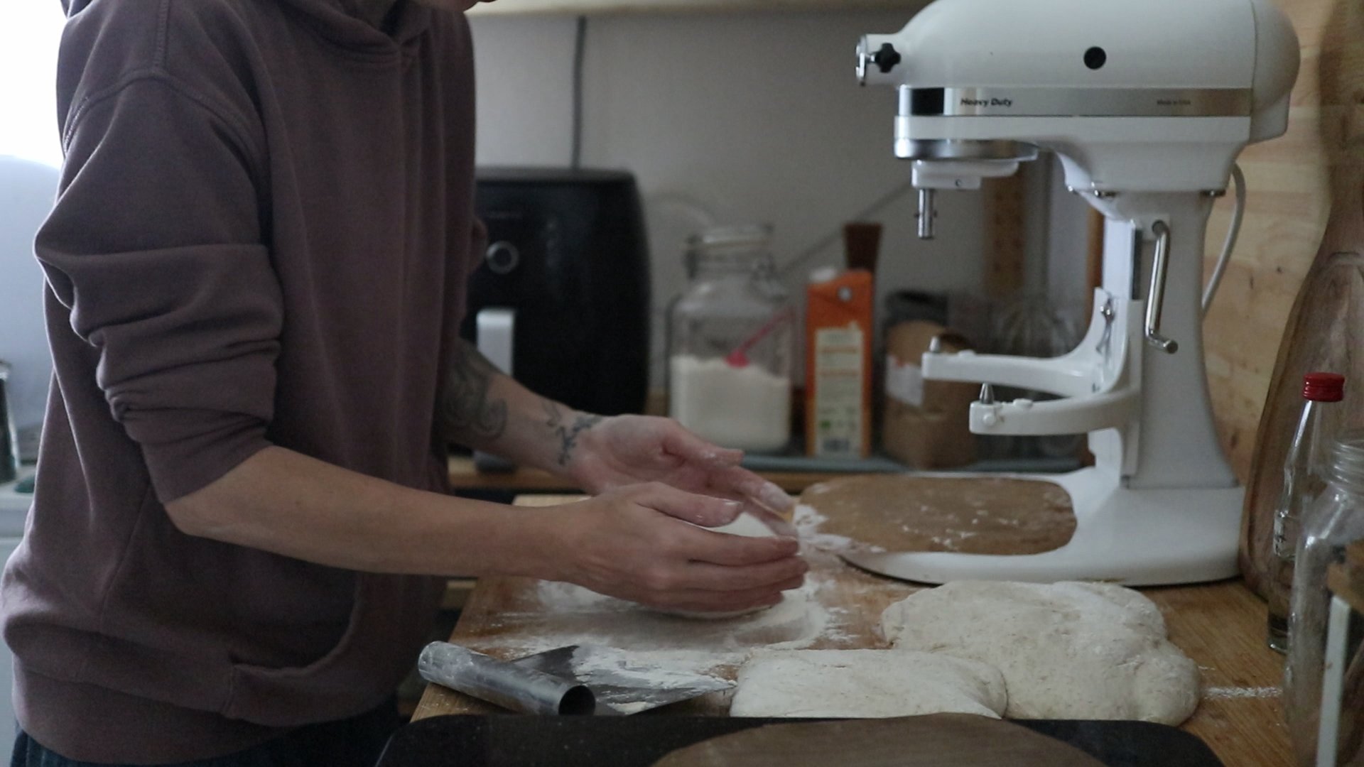 Kate formt einen kleinen Brotteig über einer sehr vollen Arbeitsplatte.